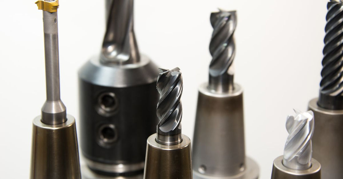 A flatlay of various best nail drill bits 2026 including carbide, diamond, and sanding bands on a white background.
