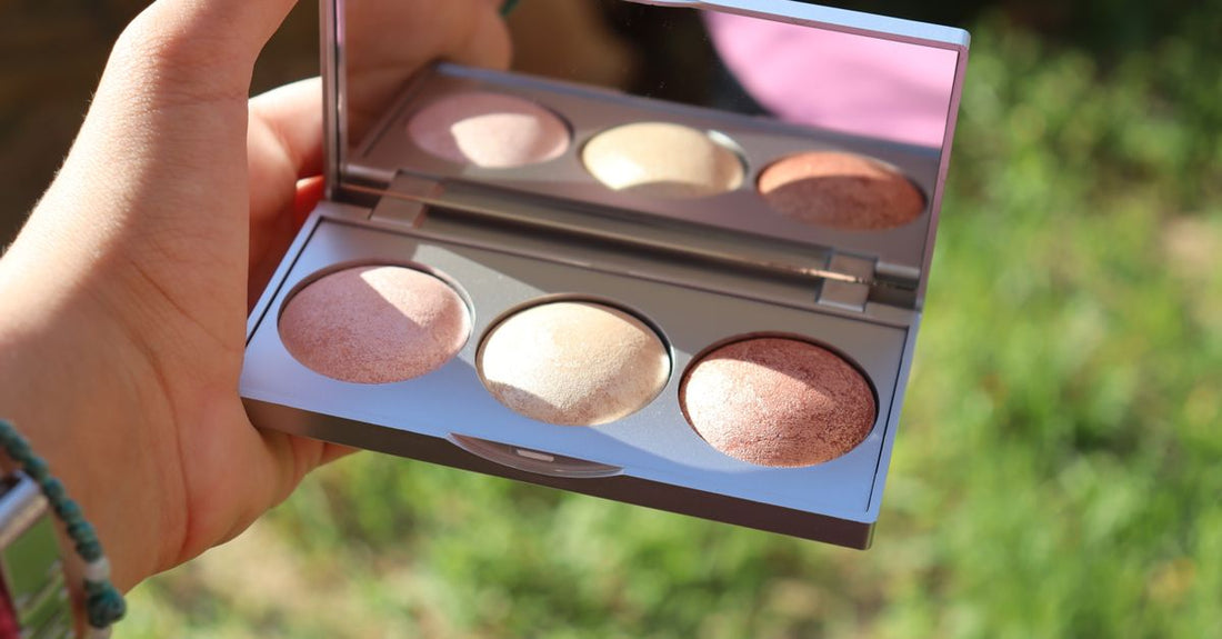A sleek highlighter palette with champagne and pearl shades, perfect for pale skin, resting on a white marble surface.