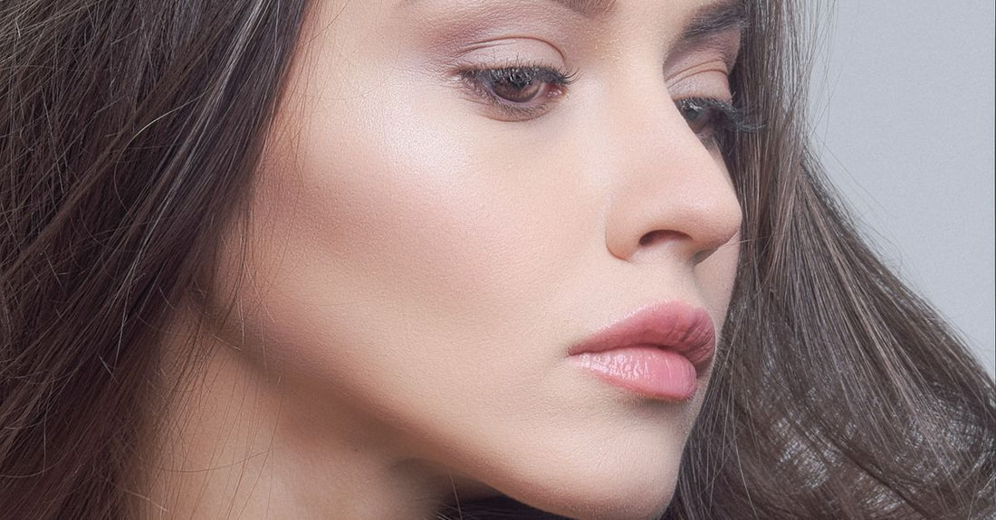 A close-up of a matte bronzer compact on a marble surface, showcasing a warm-toned powder.