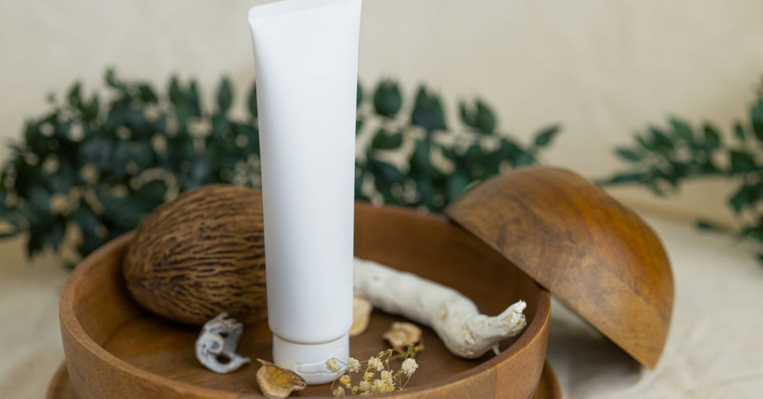 A white moisturiser jar surrounded by skincare products on a light surface, illustrating a balms & moisturisers buying guide.