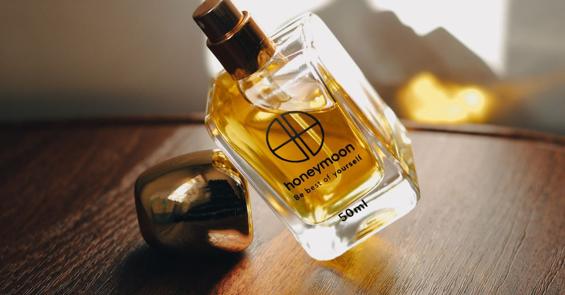 A row of assorted cologne bottles on a white shelf, illustrating a beginner’s cologne buying guide to choosing the right scent.