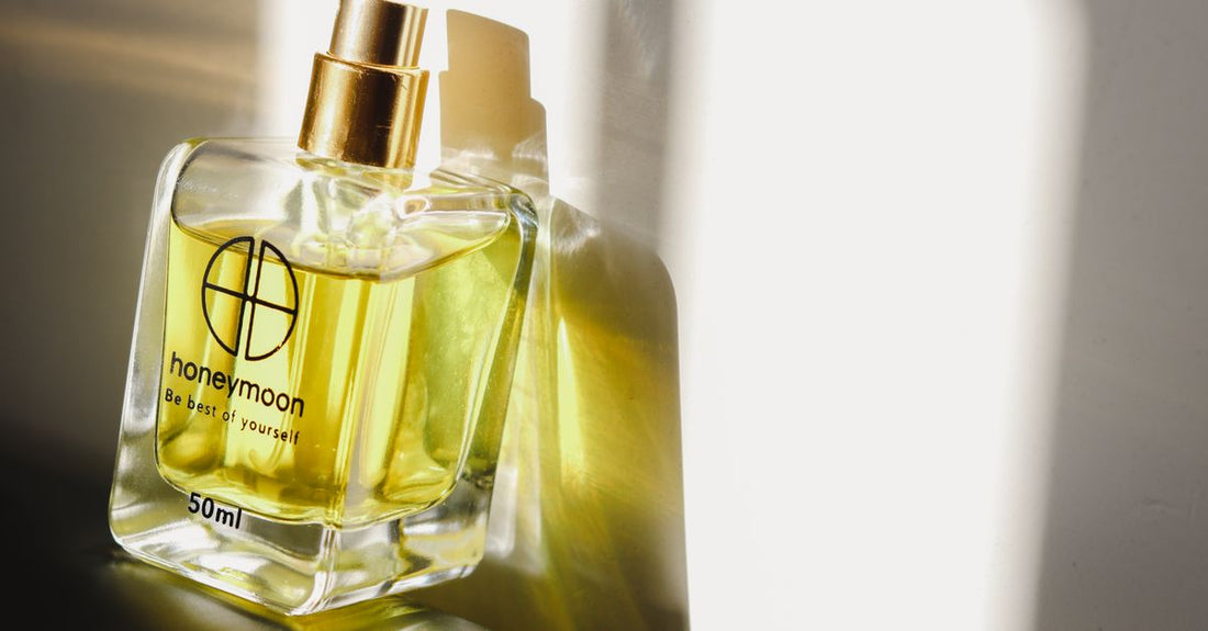 A clear eau de parfum bottle with a minimalist label on a reflective surface, illustrating a premium fragrance buying guide.
