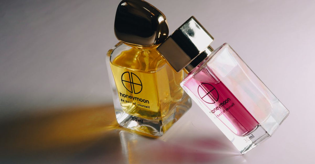 A row of colourful body spray bottles lined up on a marble surface, illustrating how to choose body sprays that match your style and mood.