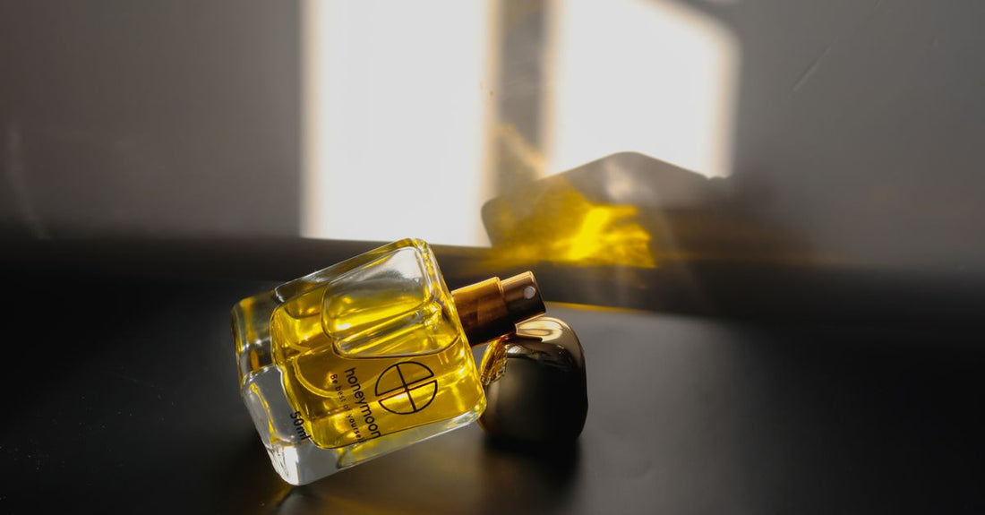 A glass eau de parfum bottle on a reflective surface, illustrating how to choose eau de parfum with confidence.