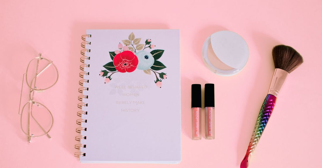 A curated flatlay of premium 2026 beauty accessories including a facial roller, LED mask and cleansing brush on a marble surface.