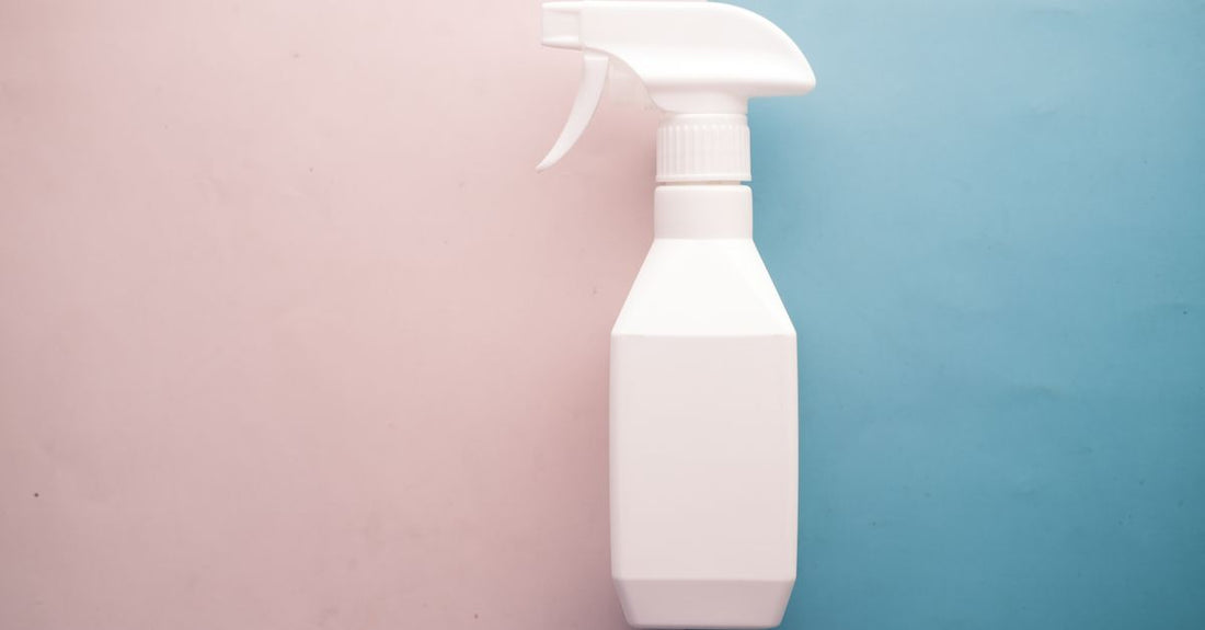 A selection of empty plastic spray bottles with adjustable nozzles laid flat on a light background, illustrating a spray bottles buying guide UK.