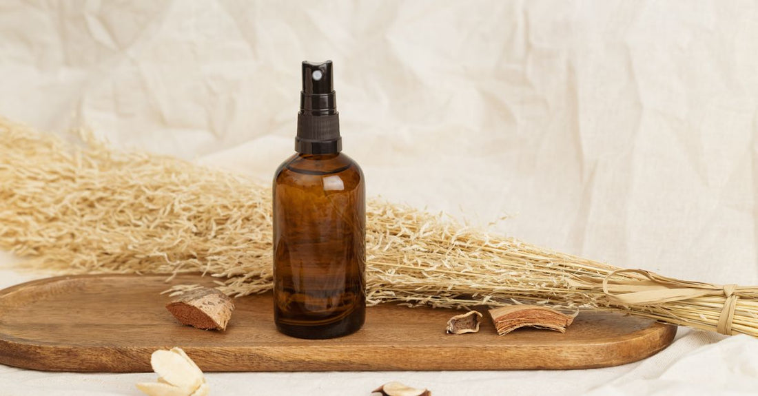 Two amber glass spray bottles with adjustable nozzles on a bathroom shelf, illustrating how to choose spray bottles UK for skincare.