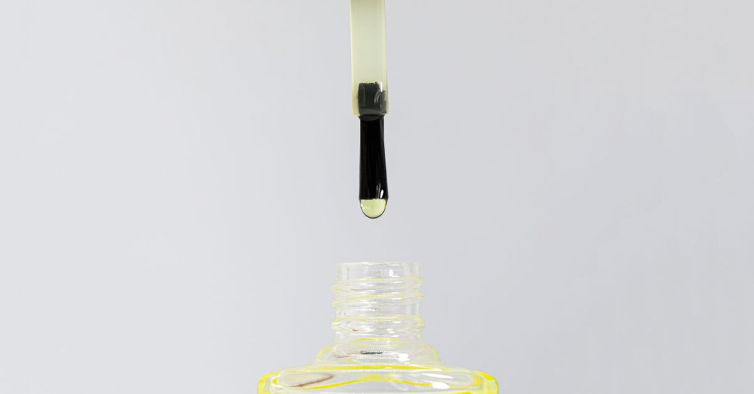 A sleek bottle of natural eyebrow growth serum resting on a marble surface, highlighting its minimalist design and precision applicator tip.