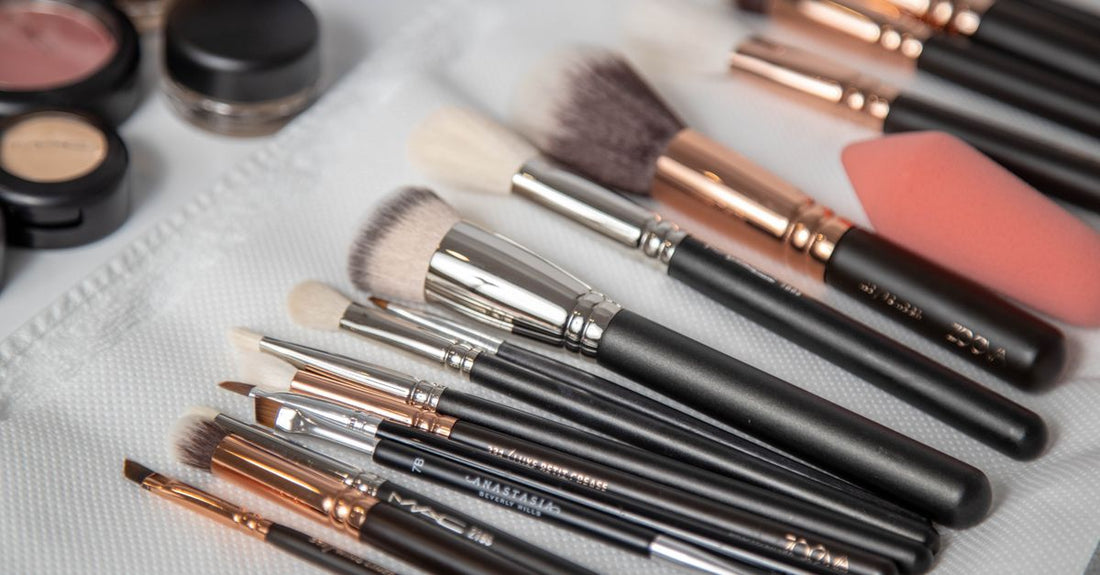 A selection of blush brushes with different head shapes laid out on a marble surface, illustrating the blush brushes buying guide.