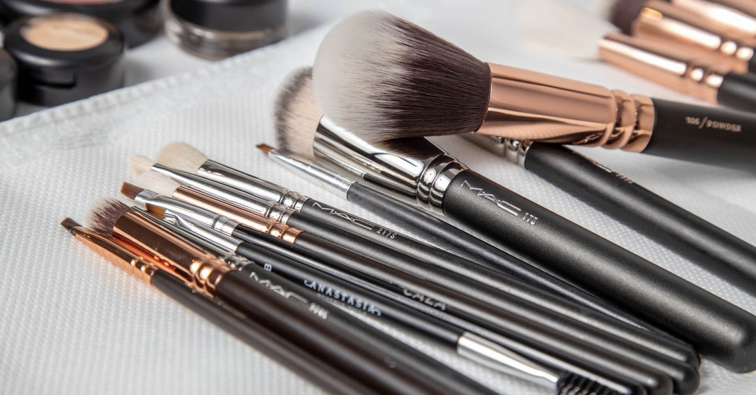 A silicone makeup brush cleaning mat with textured surfaces next to a solid brush cleanser soap on a white bathroom shelf, illustrating a brush cleaners buying guide.