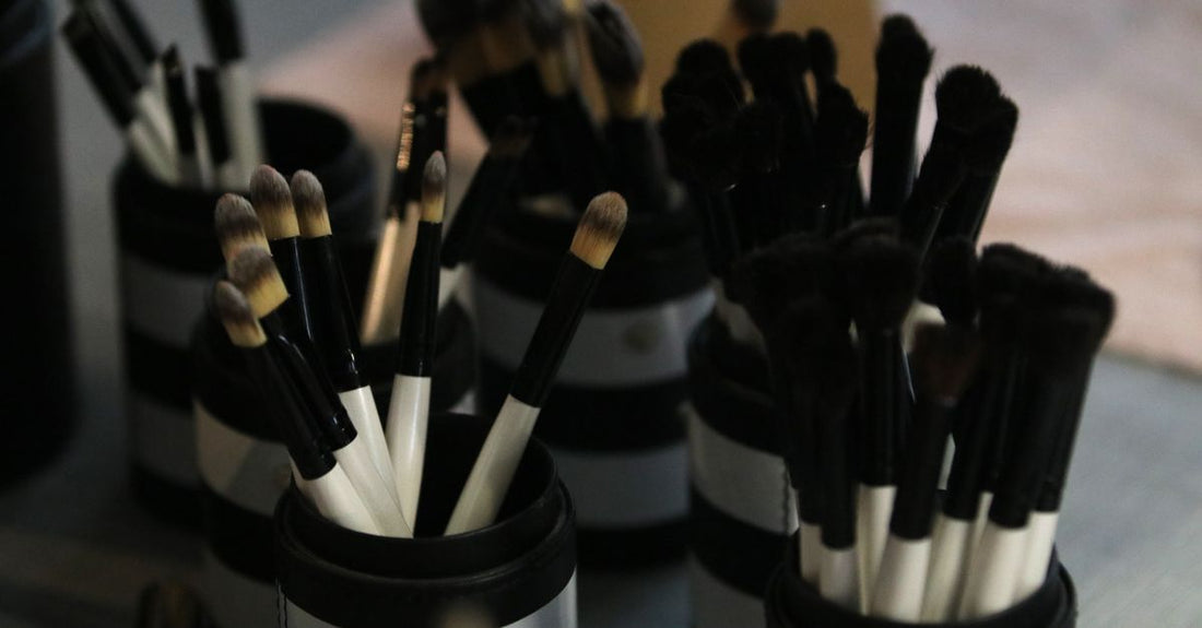 An assortment of blush brushes with different bristle shapes and fibre types laid out on a marble surface, illustrating how to choose blush brushes.