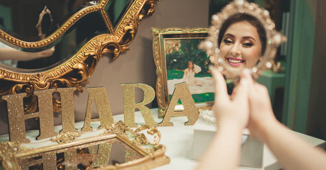 Gold vanity mirror on a white desk with skincare products, where to buy mirrors online in the UK.