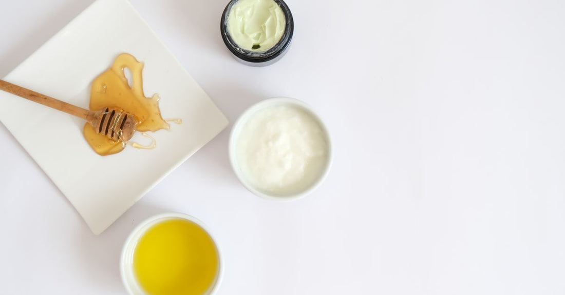 A flatlay arrangement of various moisturiser jars and tubes on a marble surface, illustrating how to choose creams for a complete morning-to-night skincare routine.