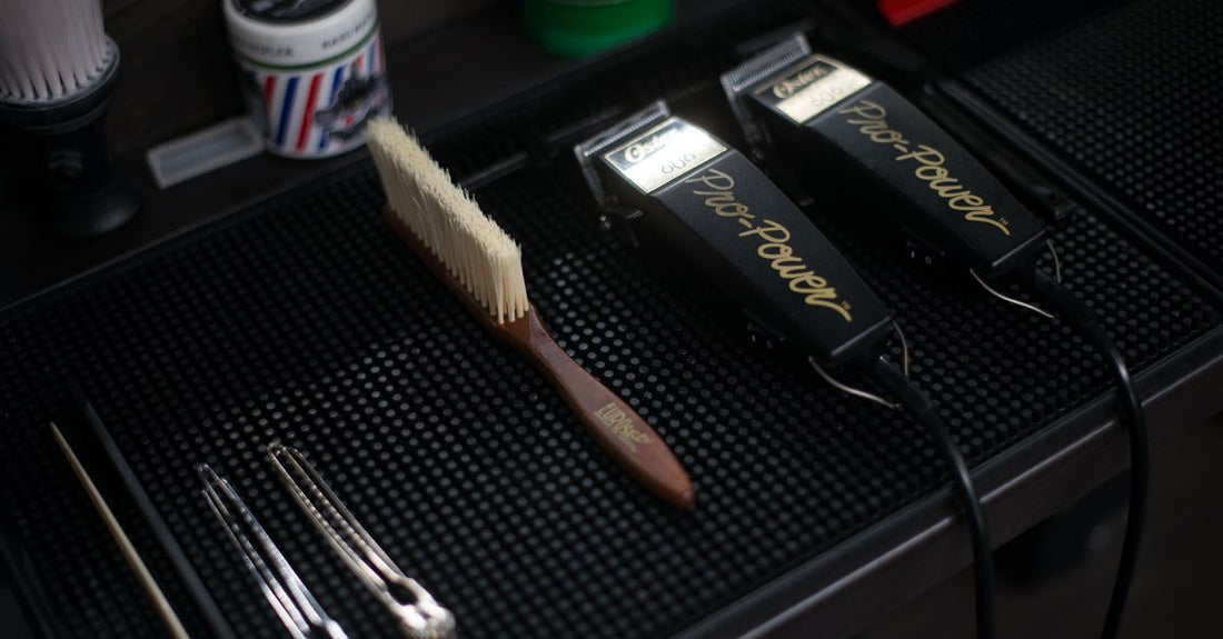 A selection of black plastic clipper combs and metal guide attachments laid out on a clean white surface, illustrating a clipper combs and guides buying guide.