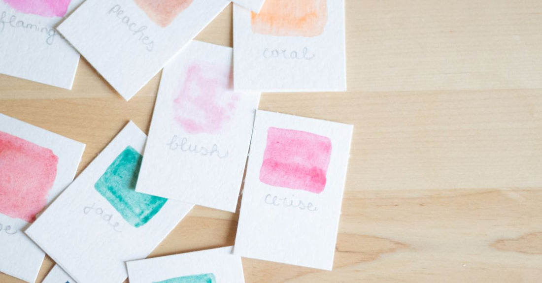 A stack of premium card stock sheets with varying finishes and weights, illustrating a card stock buying guide for beauty professionals.
