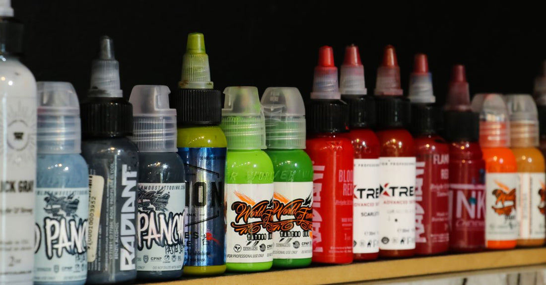 A collection of colourful tattoo ink bottles on a clean white surface, representing the best tattoo inks UK 2026 available at Avelisse.