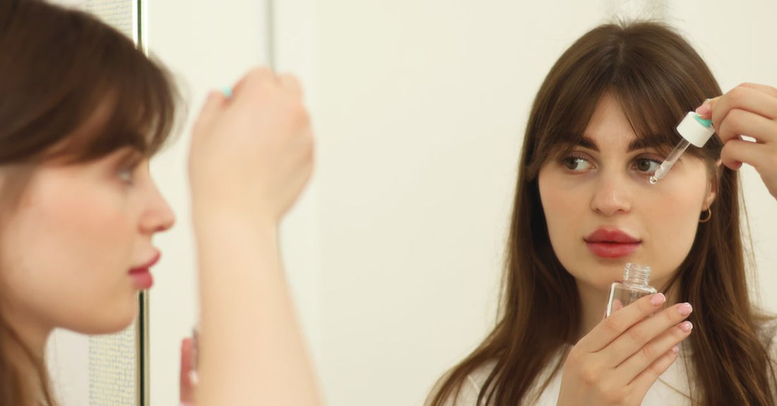 A bottle of facial tanning drops on a light background, illustrating a guide on how to use tanning drops for face.
