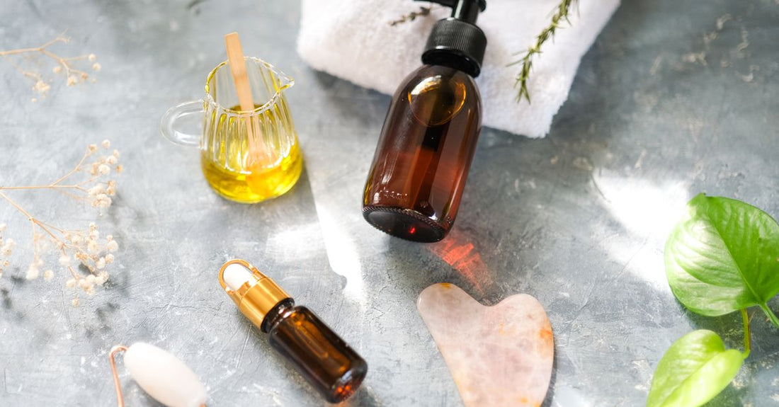 A glass bottle of body oil on a marble surface, illustrating how to use body oil for moisturizing.