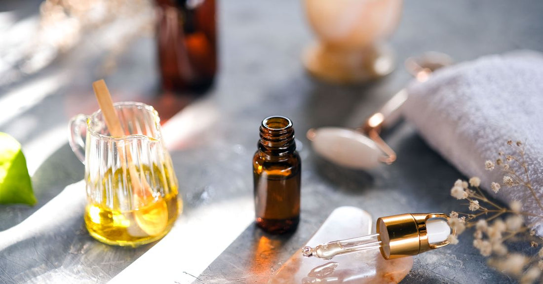A glass bottle of golden bath oil on a white marble surface, representing a premium bath oils buying guide for silky skin.