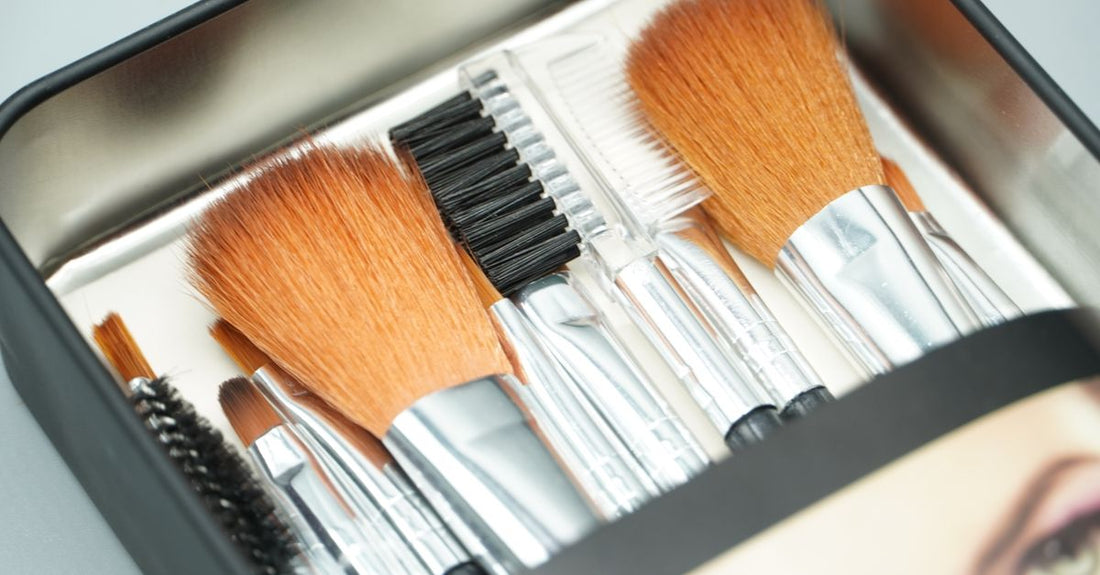A flatlay of eyebrow shaping tools including tweezers, scissors, and a brow pencil on a white background, illustrating how to shape eyebrows for your face.