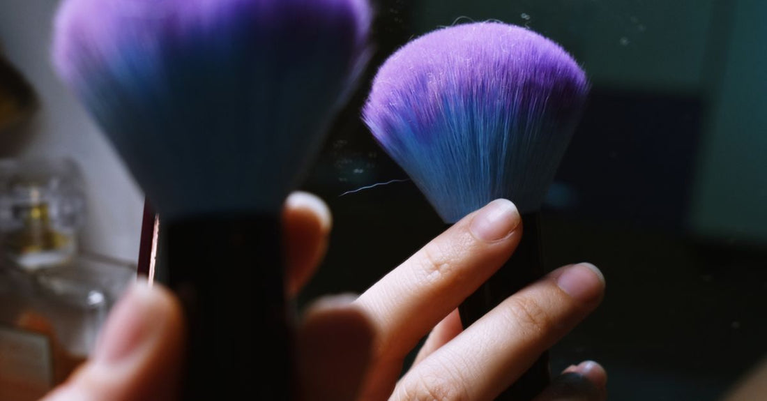 A selection of different concealer brushes laid flat, showing brush head shapes and synthetic bristle textures for how to choose concealer brushes.