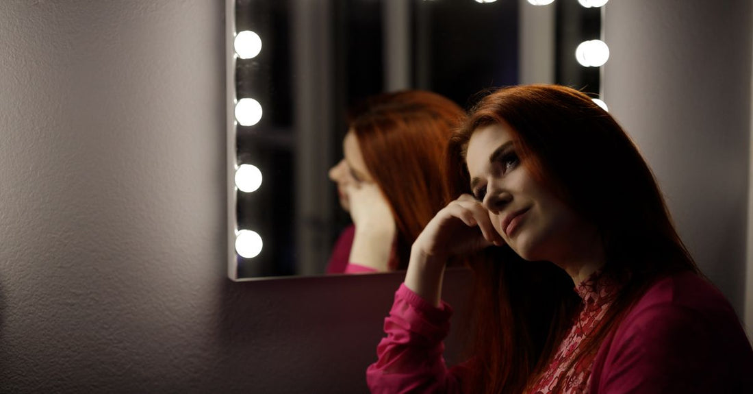 A lighted makeup mirror on a vanity table, showing its magnification and illumination features for precise makeup application.