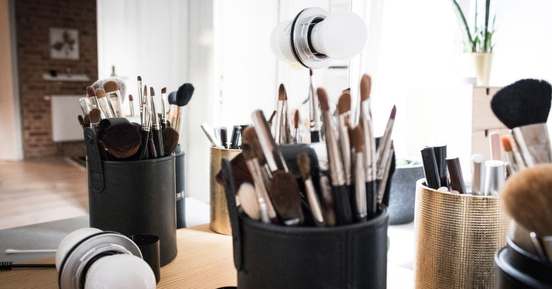 A row of makeup brush cleaner bottles in different sizes on a white shelf, illustrating how to choose brush cleaners for UK beauty routines.