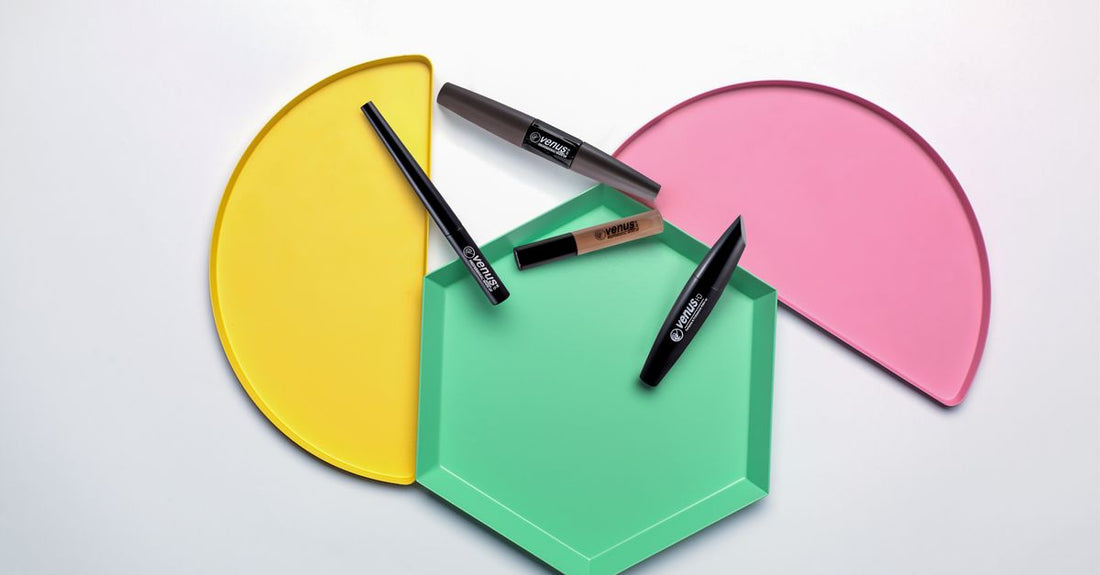 A flatlay of eyebrow colour products including pencils, powders, and gels on a white background, illustrating an eyebrow color buying guide.
