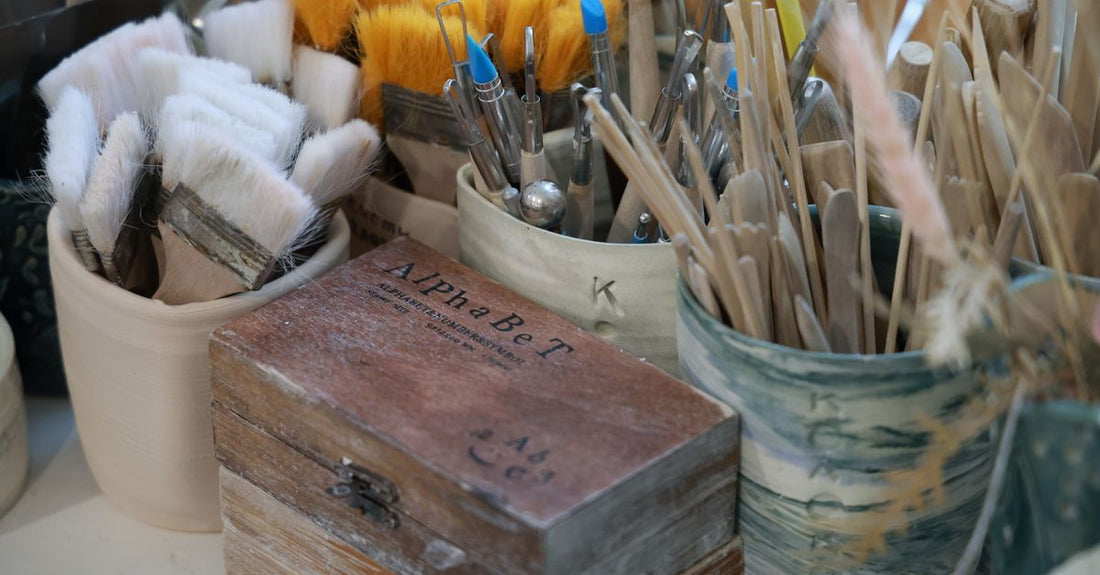 A selection of different hair brushes including paddle, round, and detangling brushes arranged on a light surface.