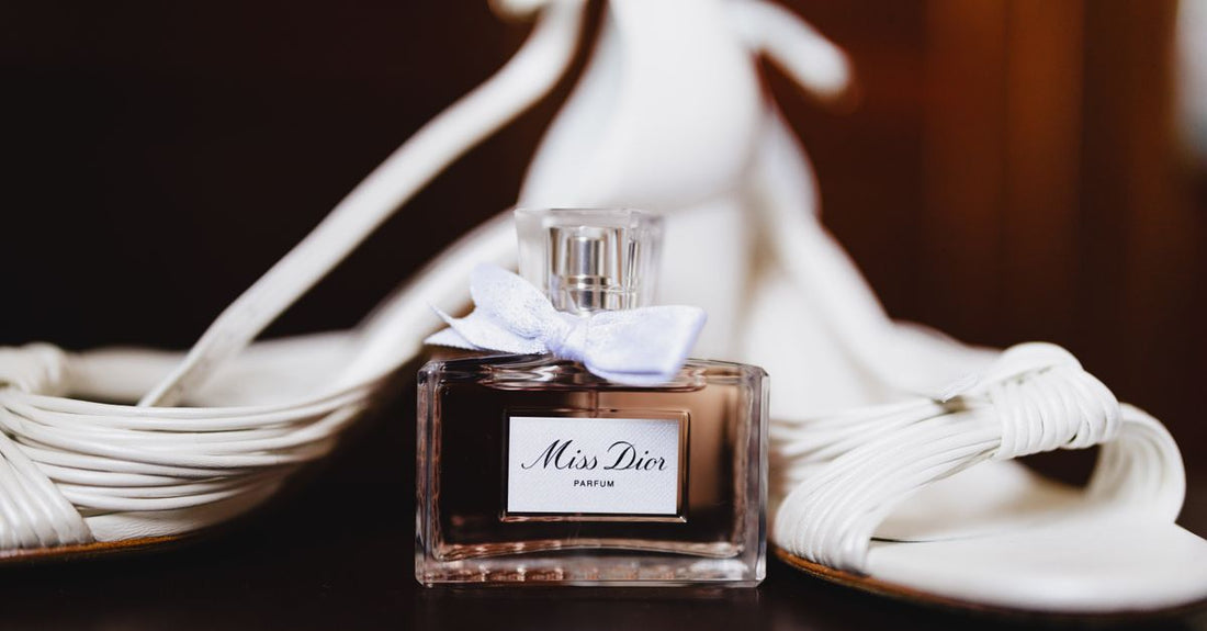 A flatlay of three luxury eau de parfum bottles on a white marble surface, demonstrating the eau de parfum buying guide topic.