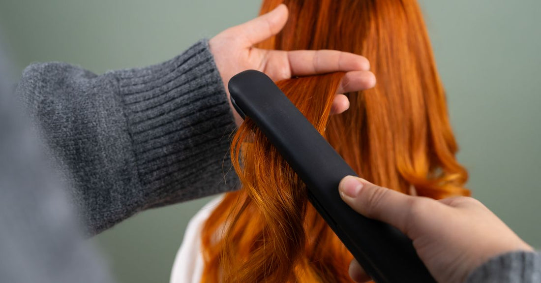 A ceramic hair straightener resting on a cool marble surface, demonstrating how to curl hair with straighteners.