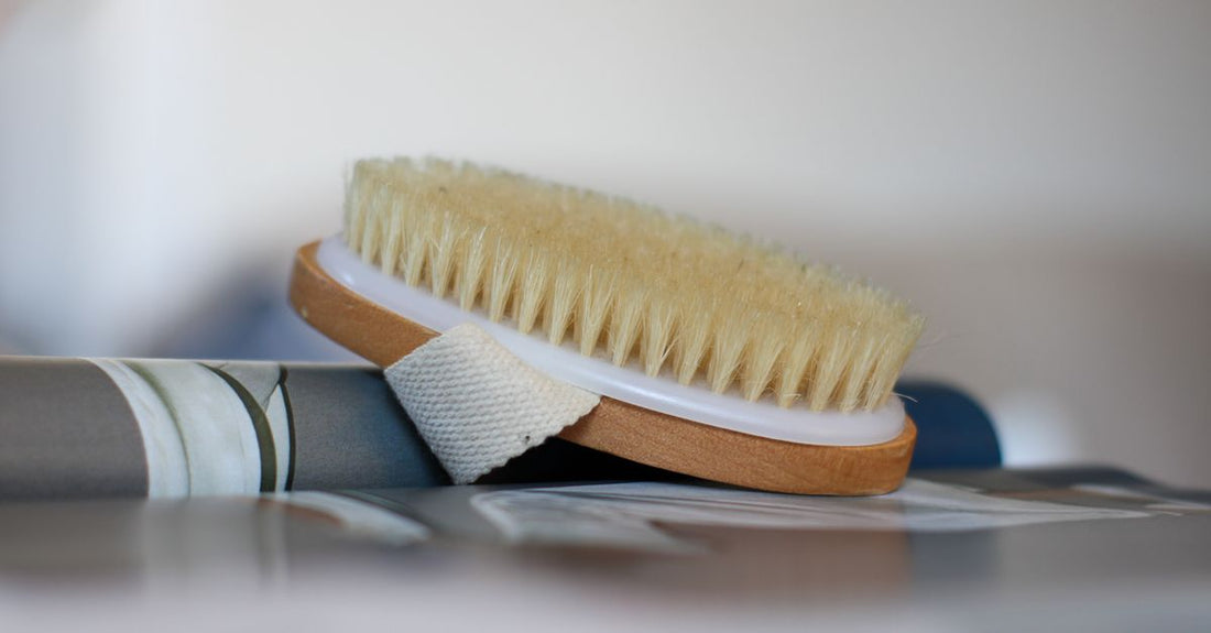 A selection of bath and body brushes on a marble surface, illustrating a bath & body brushes buying guide UK.