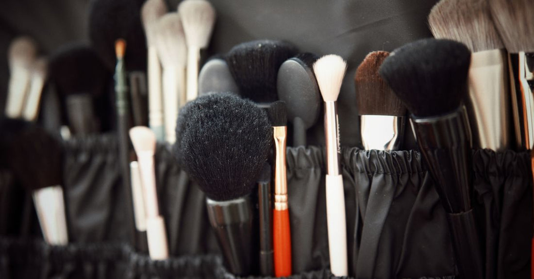 Clear acrylic cosmetic display cases neatly arranged with makeup brushes and lipsticks on a vanity table, showing a organised UK beauty setup.