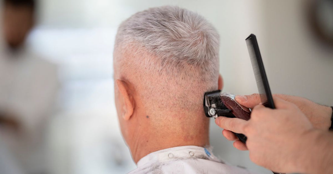 A professional hair clipper resting on a clean white surface, showing the blade and ergonomic body, illustrating how to choose hair clippers based on build quality.