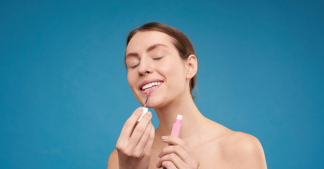 A row of pastel-coloured lip gloss tubes on a clean white surface, illustrating a lip glosses buying guide for safe gifting.