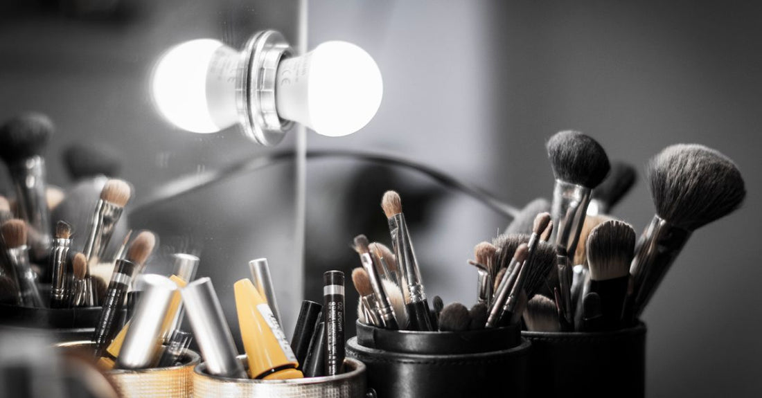 A flatlay of a complete makeup brush set with synthetic bristles, including foundation, blush, and eyeshadow brushes, on a white marble background.