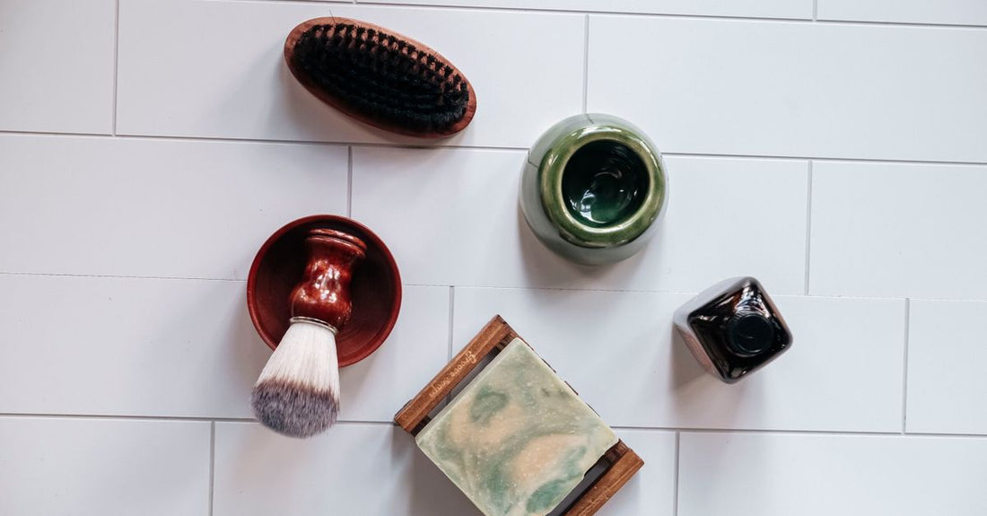 A flatlay of different bath and body brushes on a neutral background, showing bristle types and handle lengths, illustrating how to choose bath & body brushes.