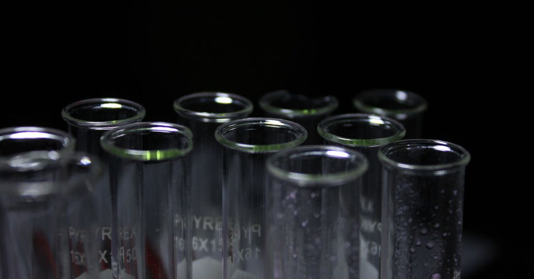A glass of water with a strand of hair floating, illustrating a hair porosity test for how to choose conditioners.
