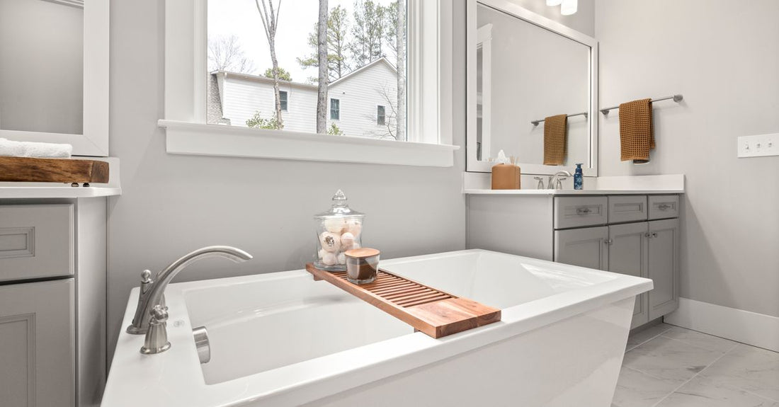 A jar of luxury bath salts beside a wooden scoop on a light bathroom shelf, representing the best bath salts 2026 available at Avelisse.