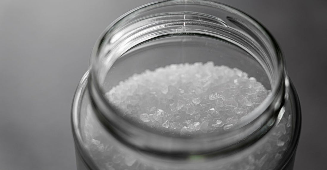 How to use bath salts for relaxation: glass jar of mineral bath salts on a serene bathroom shelf
