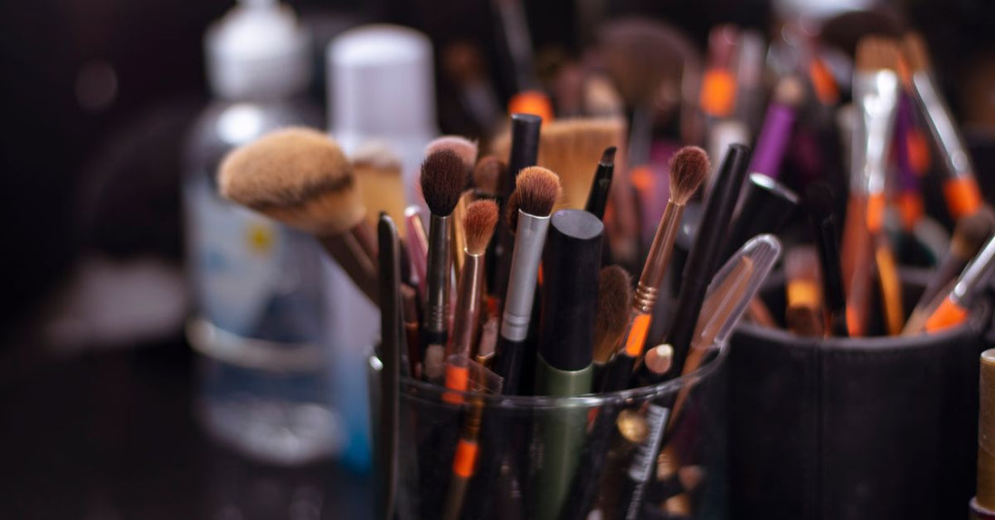 A makeup brush cleaner spray bottle and a brush on a marble surface, illustrating a brush cleaners buying guide for UK shoppers.