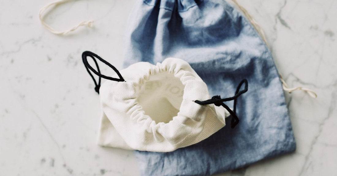 A selection of clear and hanging cosmetic bags arranged on a marble surface, illustrating how to choose cosmetic bags for summer travel and daily use.