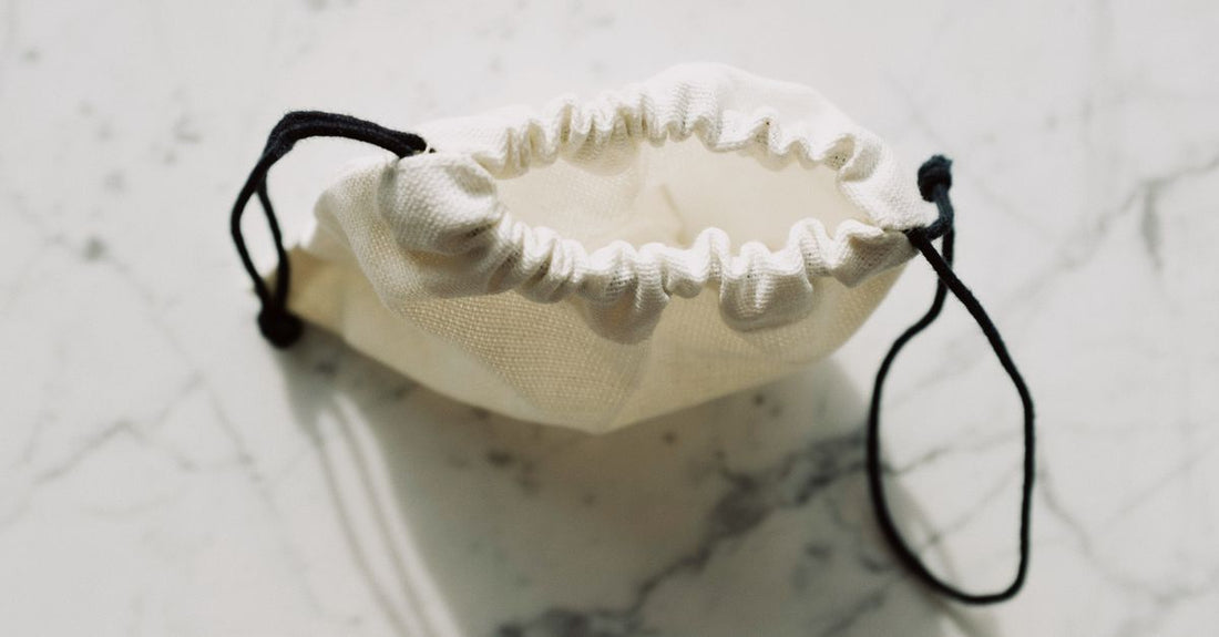 Best cosmetic bags 2026 displayed in a flatlay with brushes and skincare products on a marble surface.