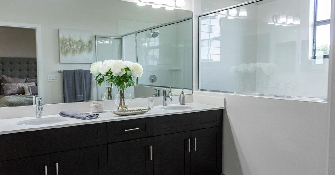 A clear acrylic cosmetic display case holding lipsticks and compacts on a white vanity, illustrating a cosmetic display cases buying guide.