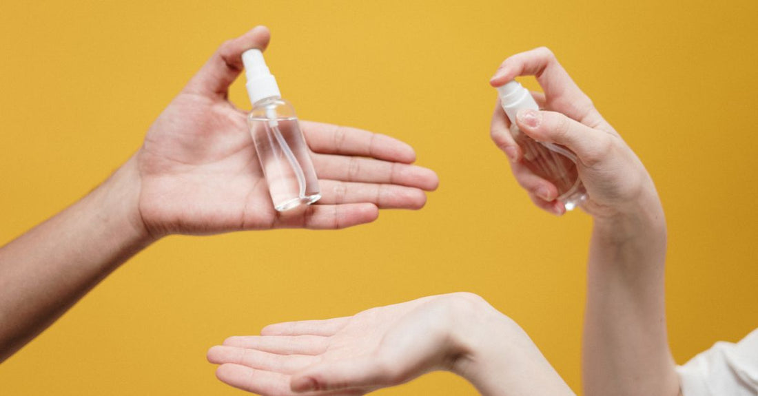 A flatlay of various body spray bottles in different sizes and colours on a light background, illustrating a body sprays buying guide.