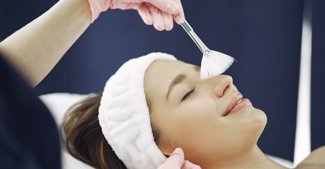 Best facial peels 2026: a flatlay of chemical exfoliant bottles with droppers and pumps on a neutral background.