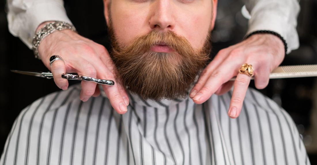 Close-up of professional beard trimming scissors resting on a grooming comb, with a tidy background, illustrating how to trim beard with scissors precisely.