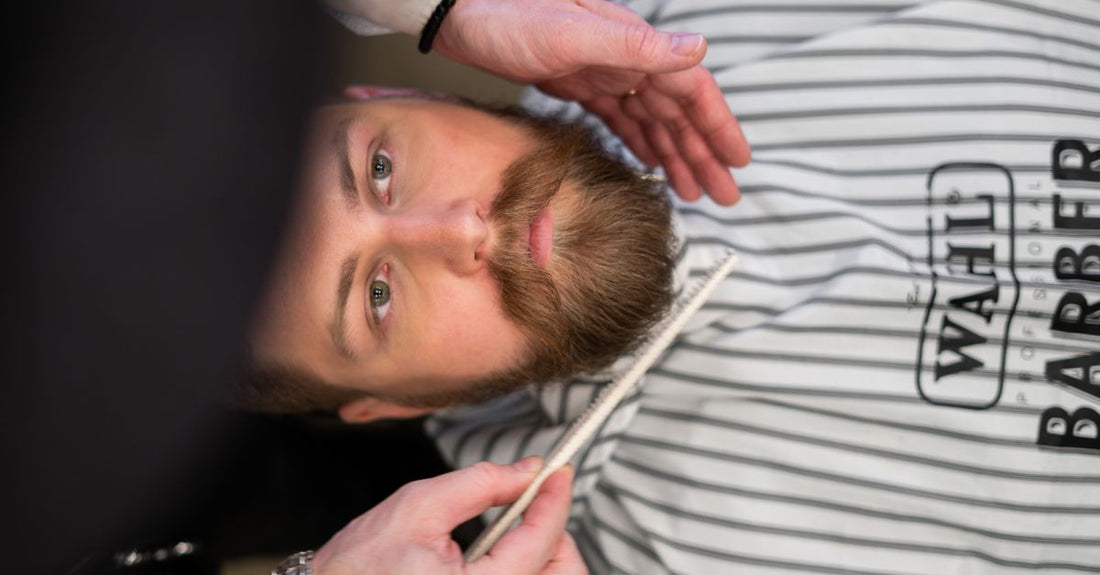 A flatlay of two wooden beard and mustache combs on a neutral background, part of a beard & mustache combs buying guide.