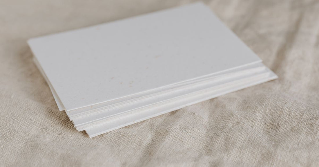 A stack of blotting paper sheets on a clean white surface, ready to be used for absorbing facial oil and shine.