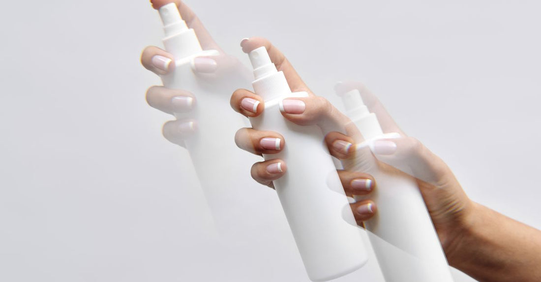 Hair spray bottle releasing a fine mist over a neutral background, demonstrating how to use hair spray without stickiness